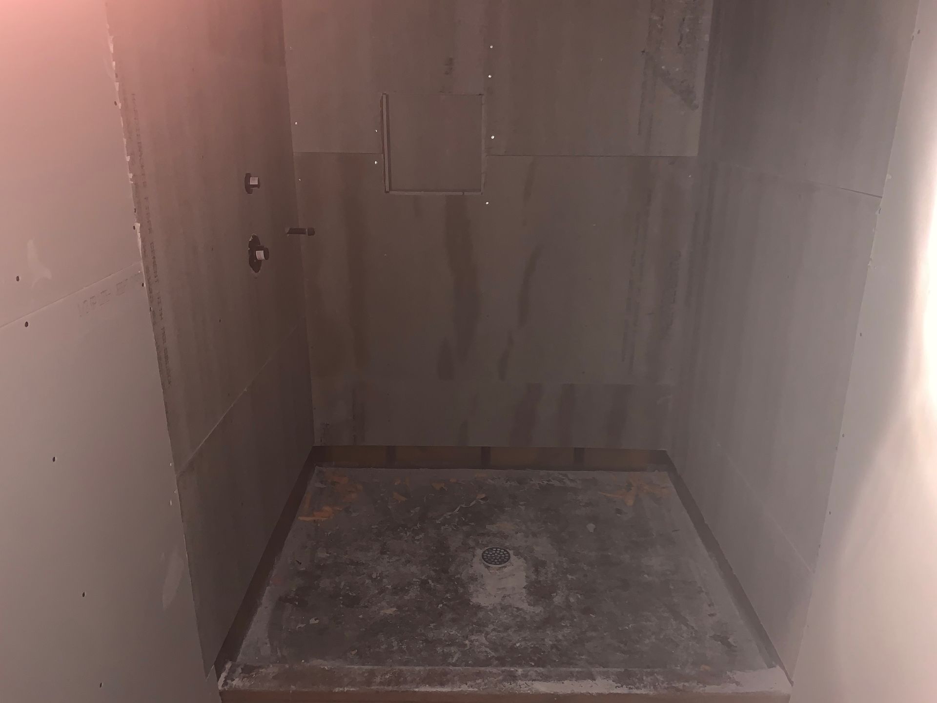 A shower stall is being built in a bathroom.