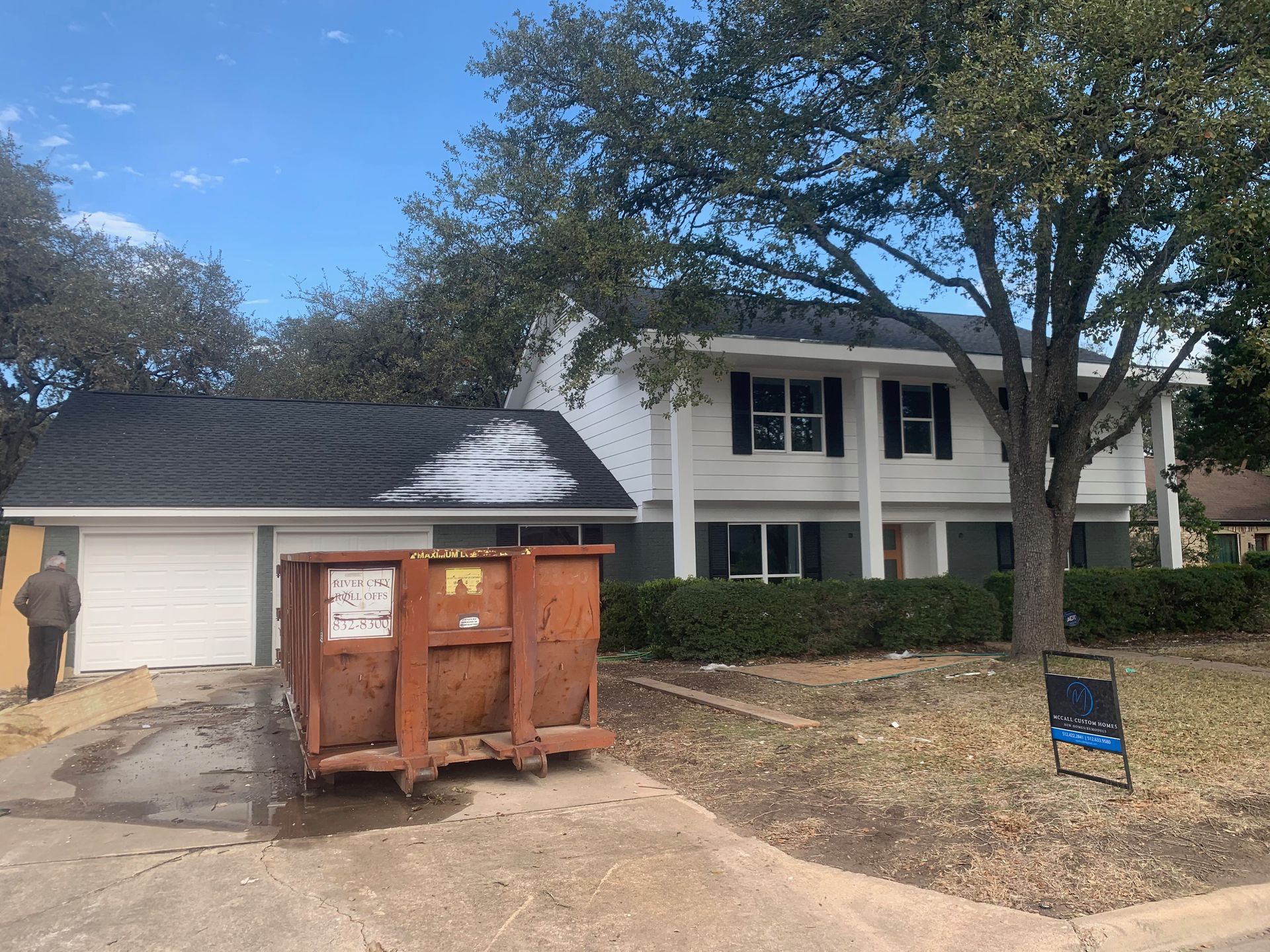 A large house with a dumpster in front of it.