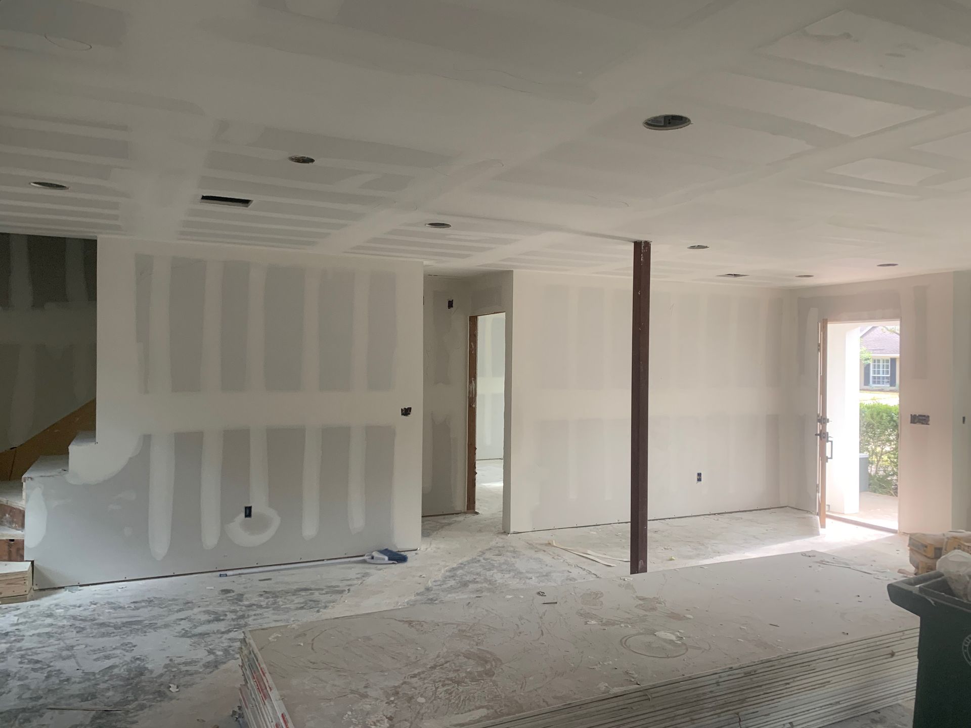 An empty room with a staircase and a door.