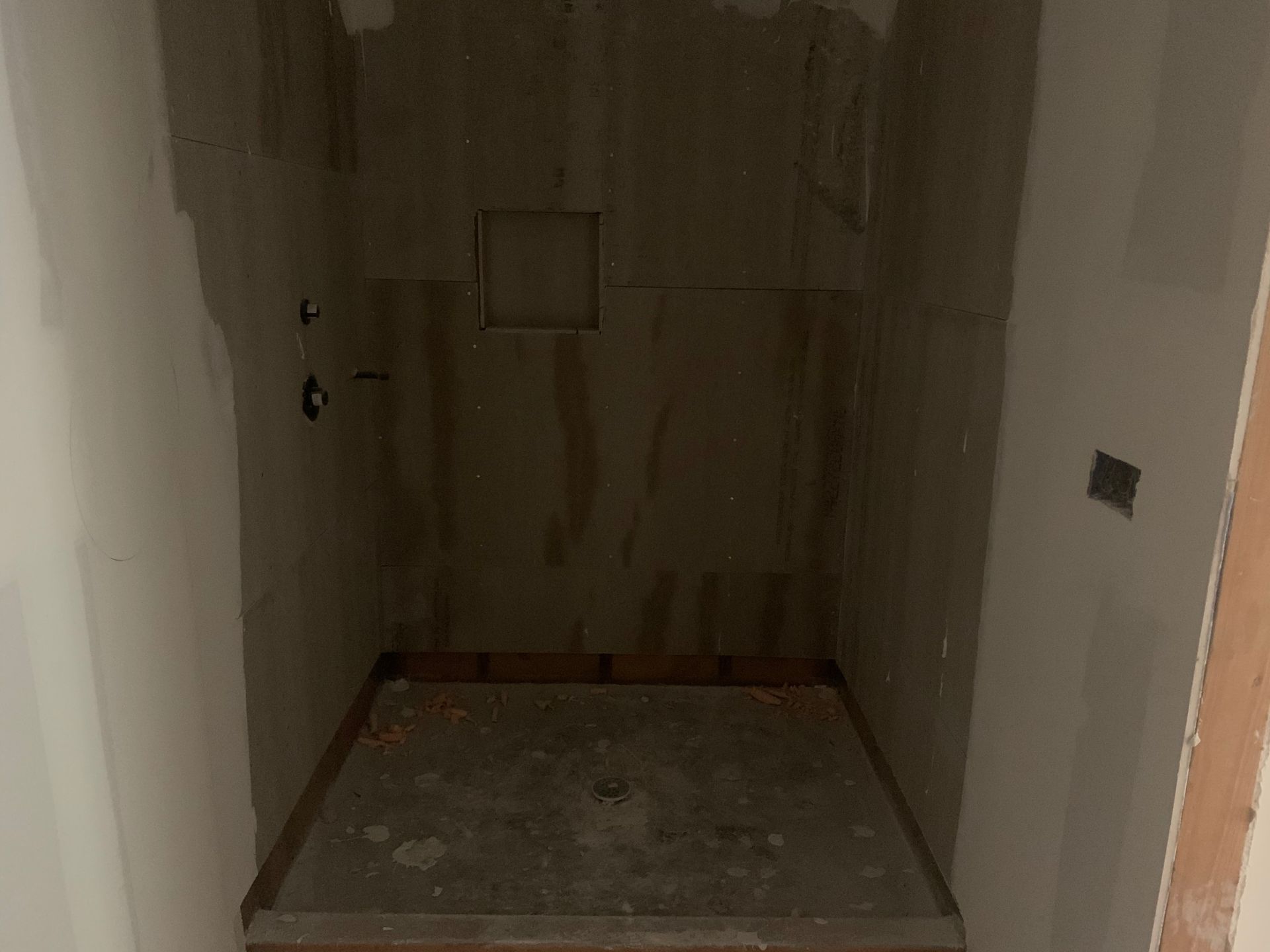 A shower stall is being built in a bathroom.