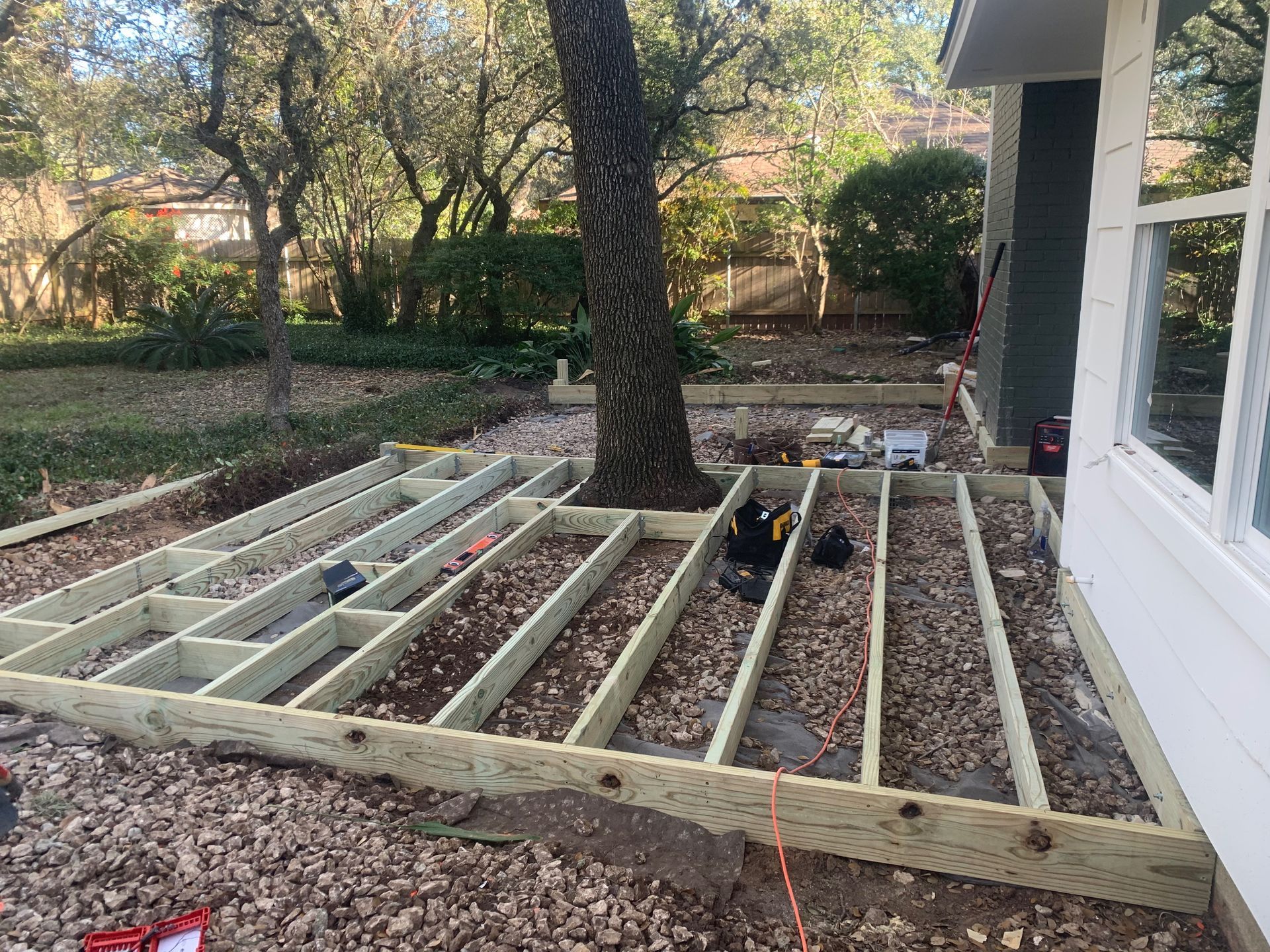 A wooden deck is being built in front of a house.