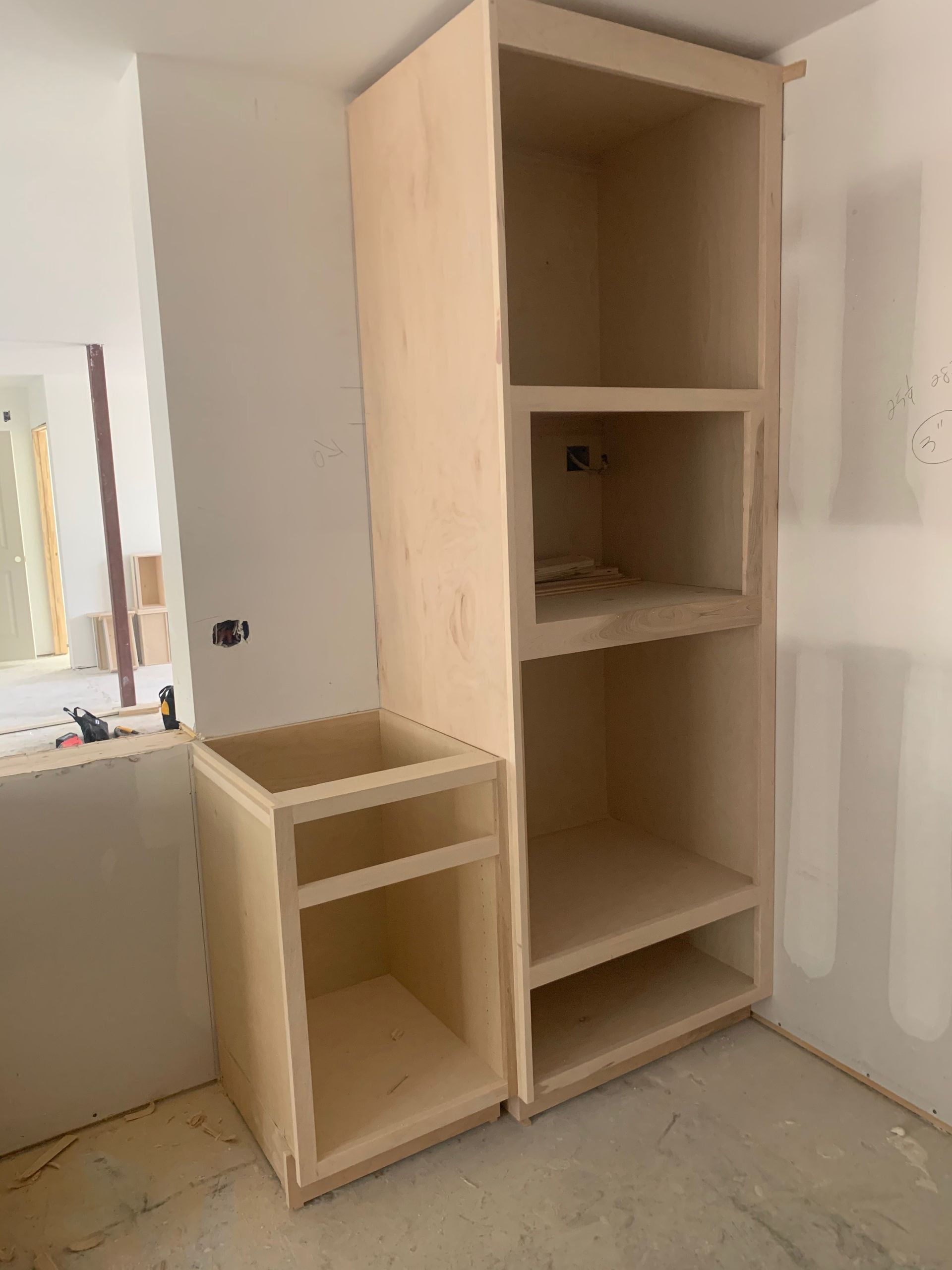 A wooden cabinet is being built in a bathroom.