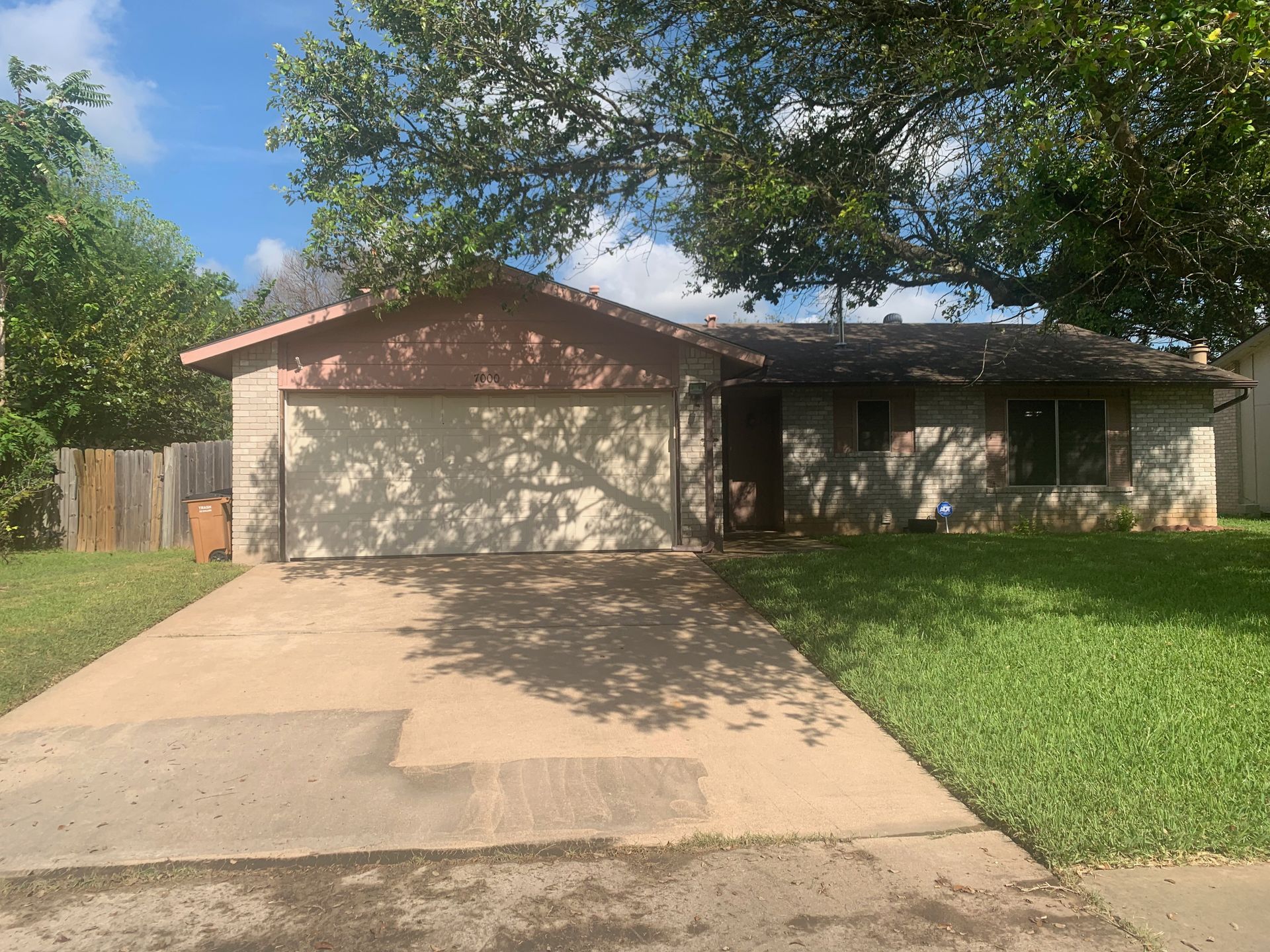 A house with a garage and a driveway in front of it.