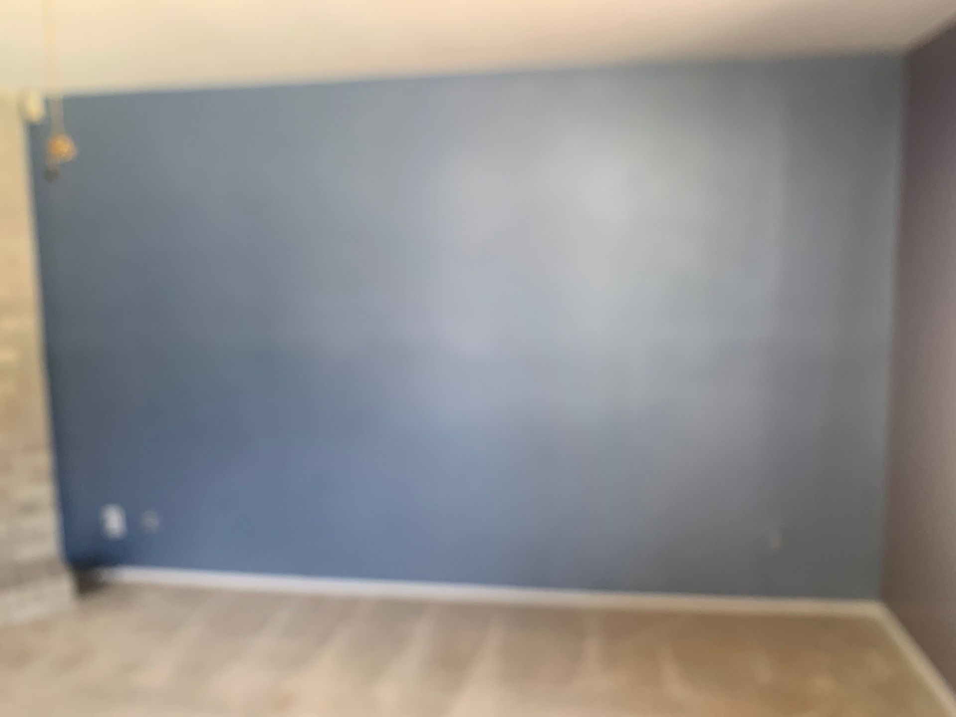 A room with a blue wall and a gray floor.