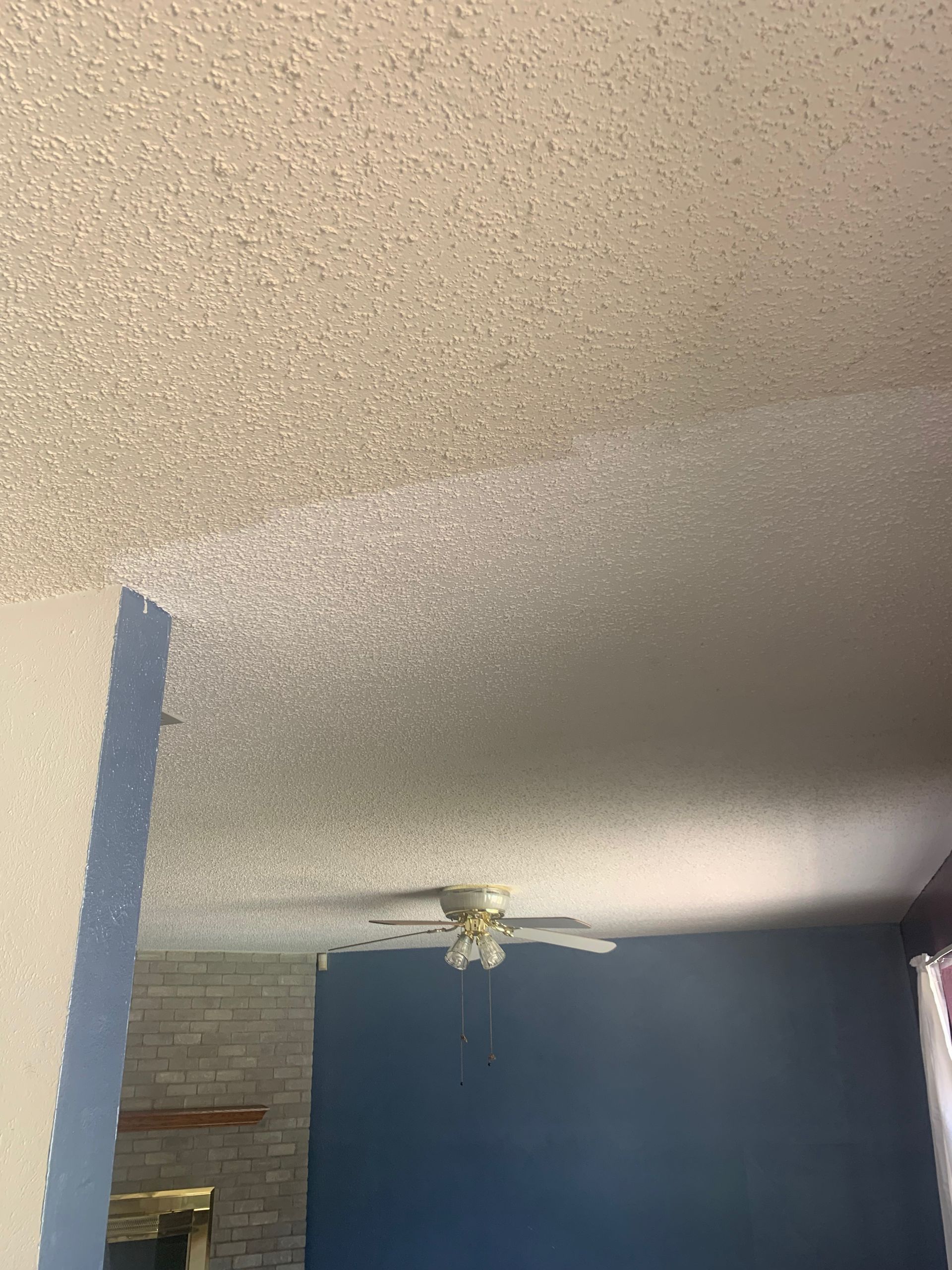 A ceiling fan is hanging from the ceiling of a room.