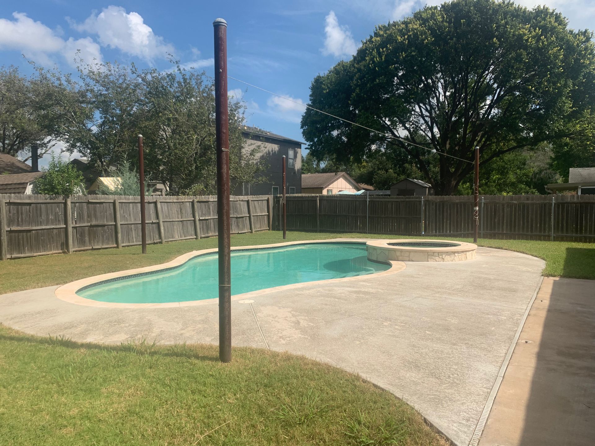 There is a large swimming pool in the backyard of a house.