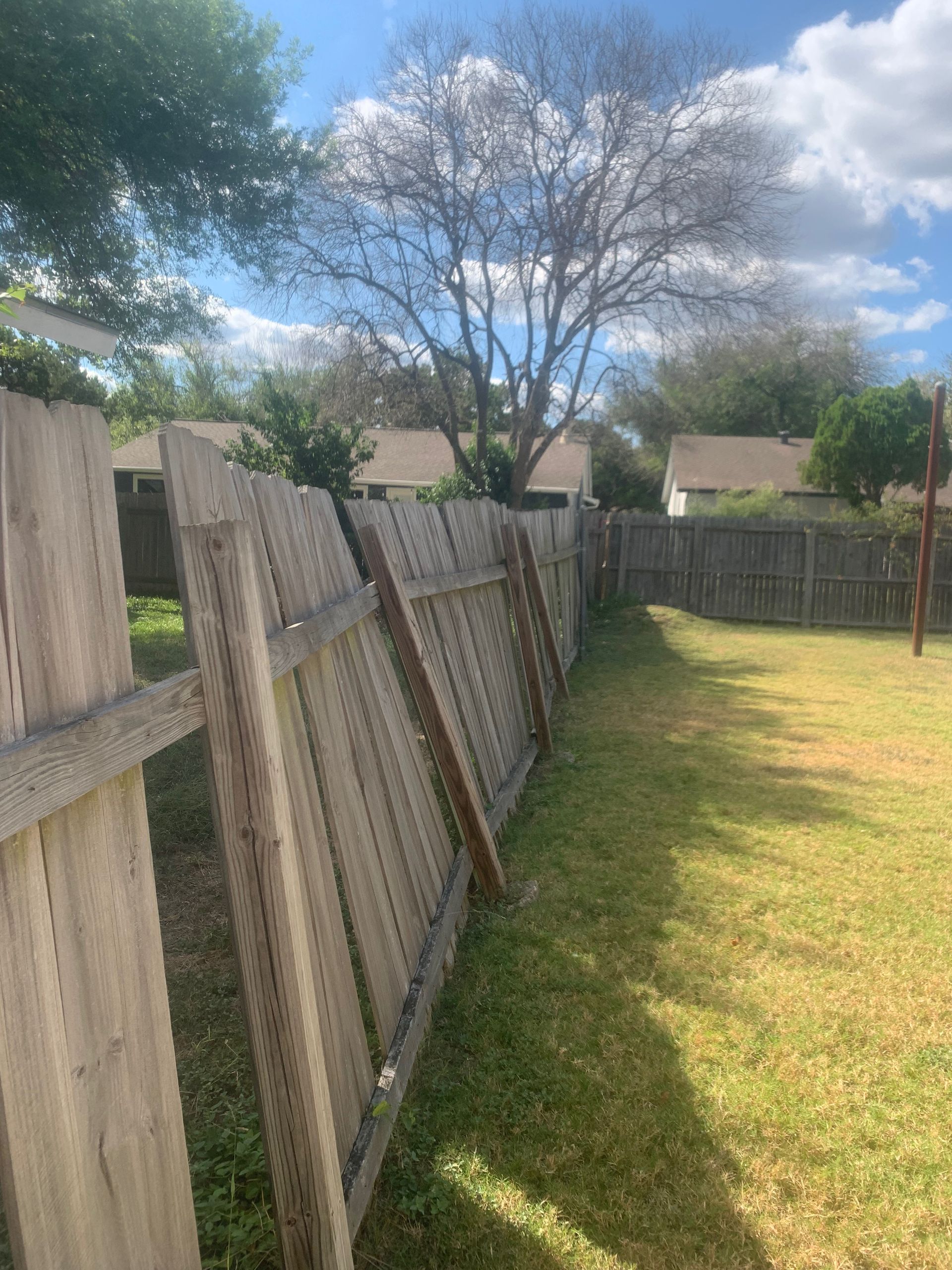 A wooden fence is sitting in the middle of a grassy yard.