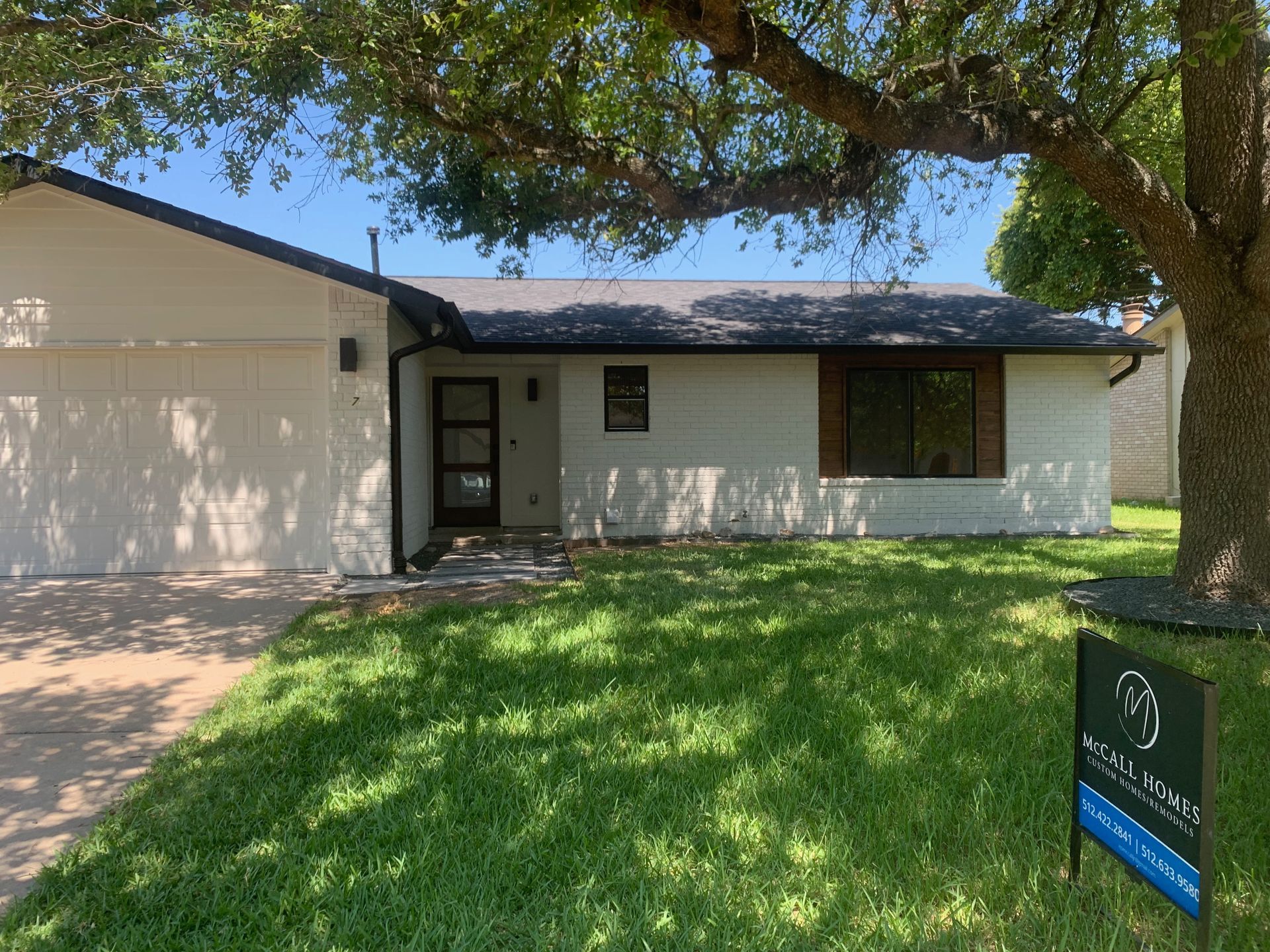 A house with a for sale sign in front of it.