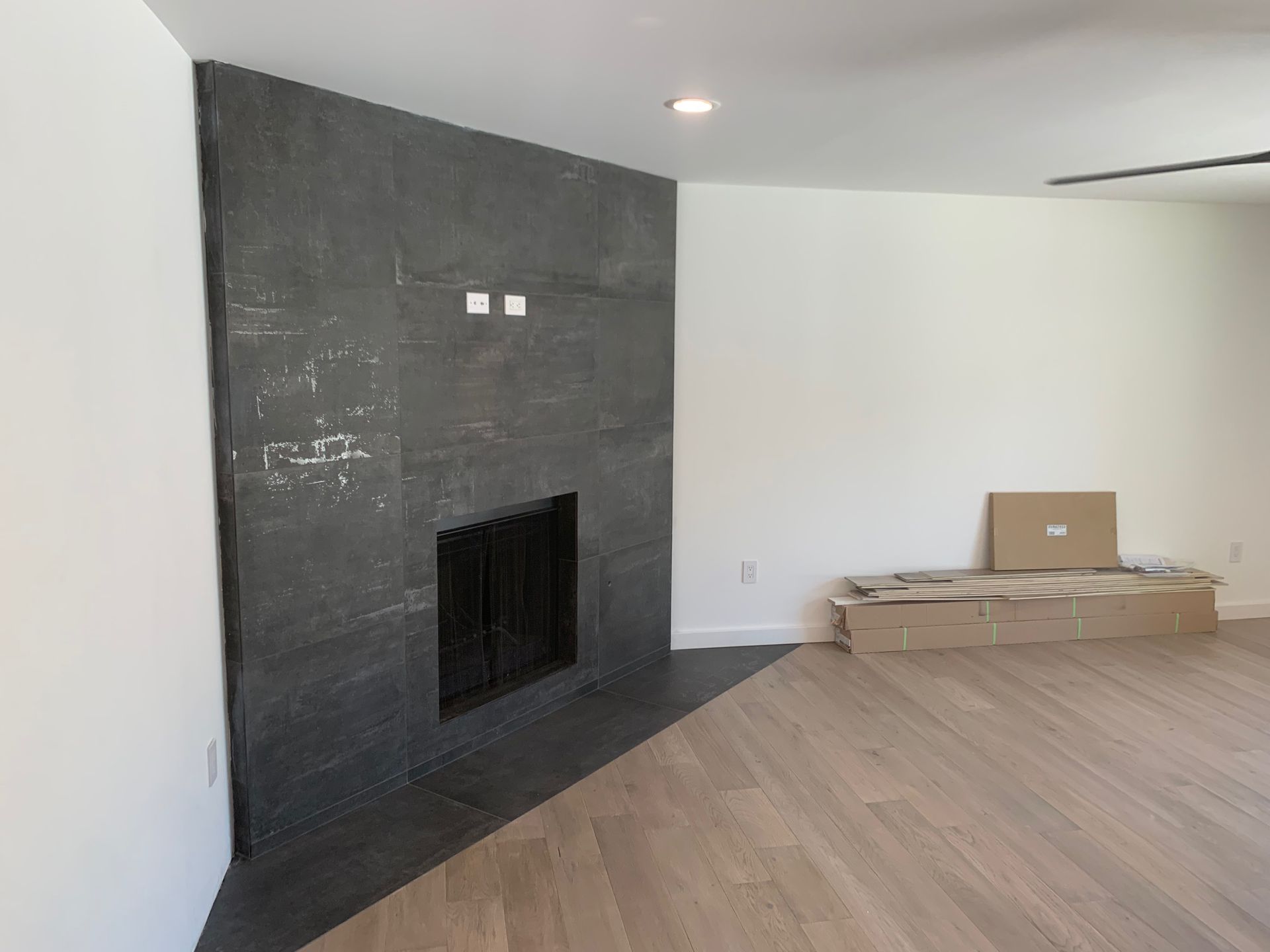 A living room with a fireplace and wooden floors.