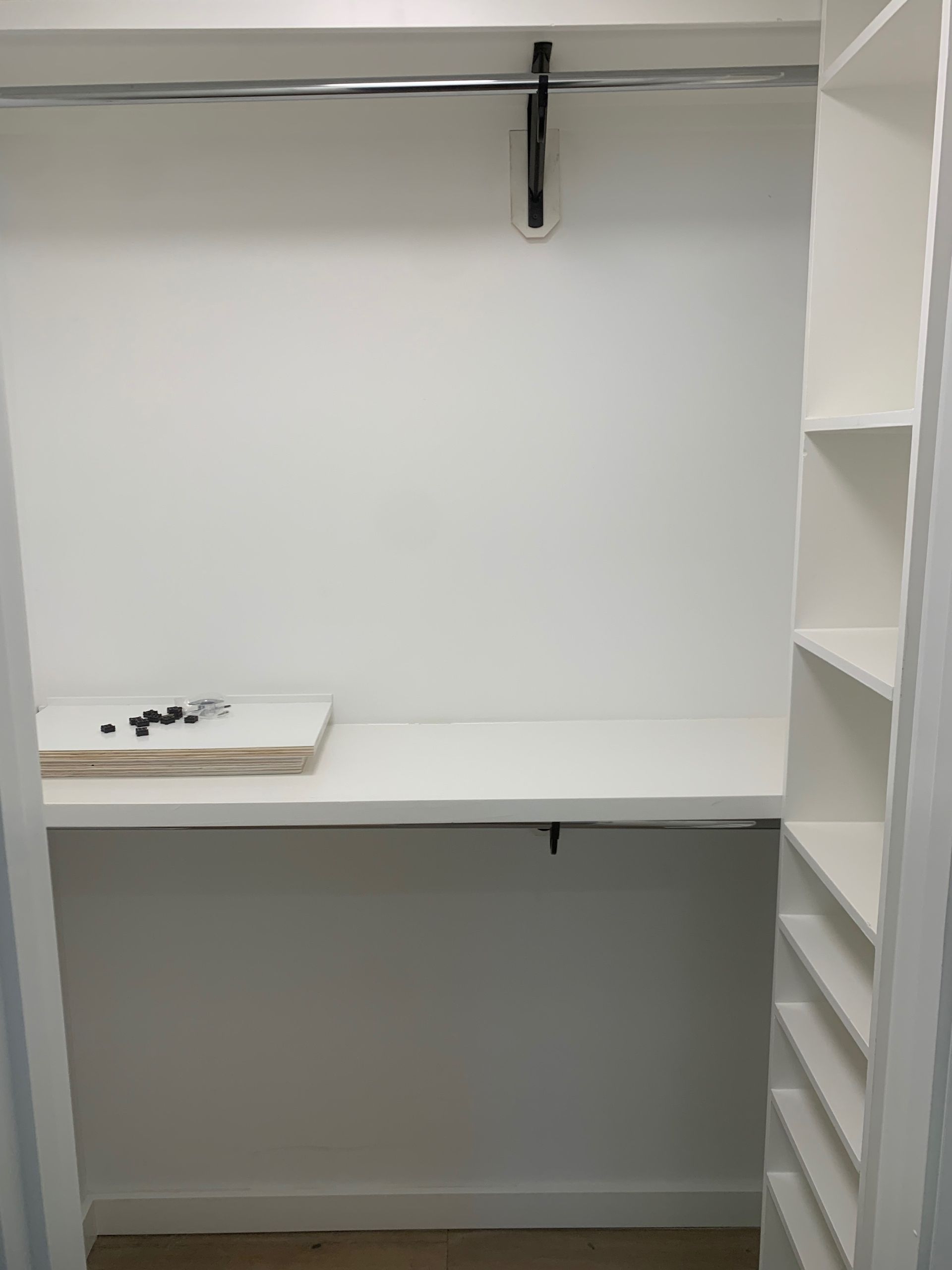 A closet with a table and shelves in it.
