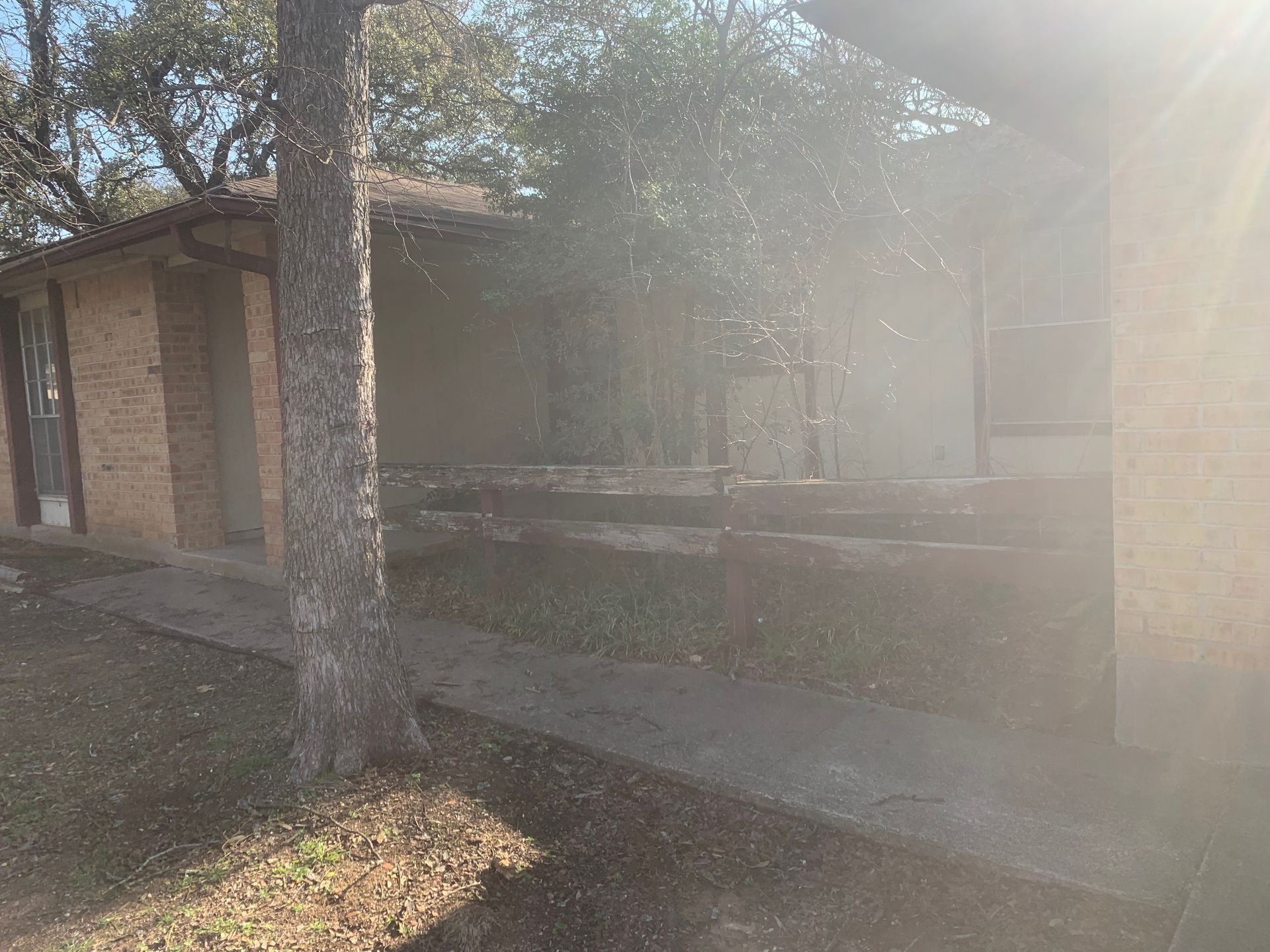 A brick house with a tree in front of it.