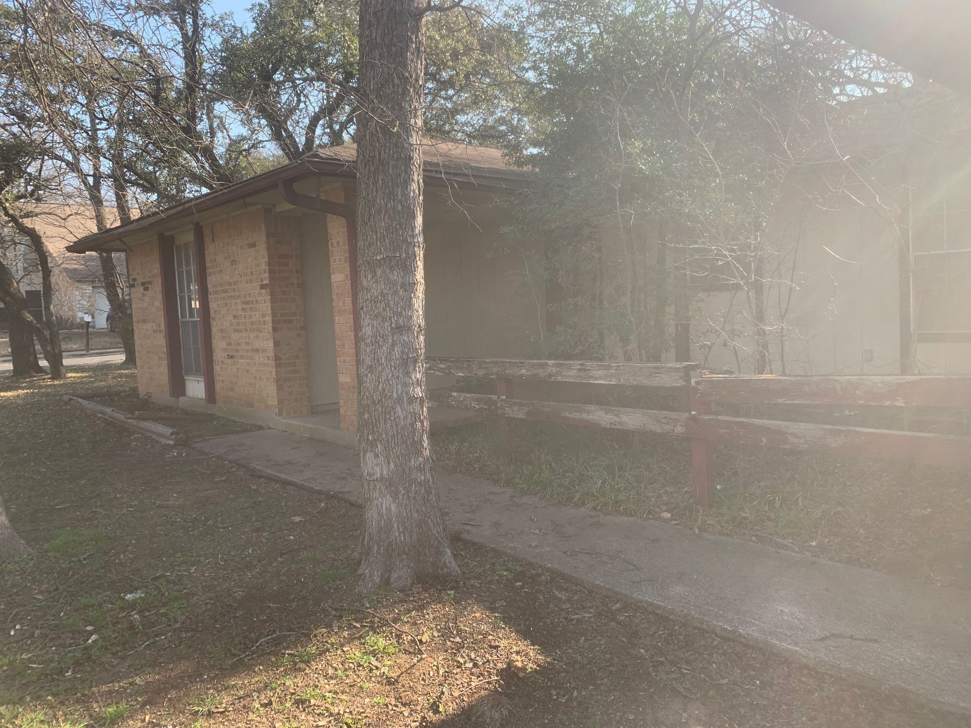 A brick building with a tree in front of it in a park.