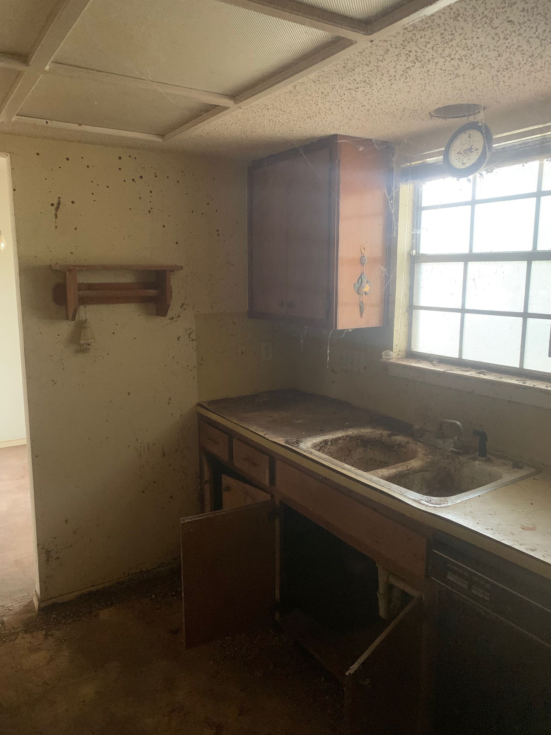 A kitchen with a sink and a clock on the ceiling.