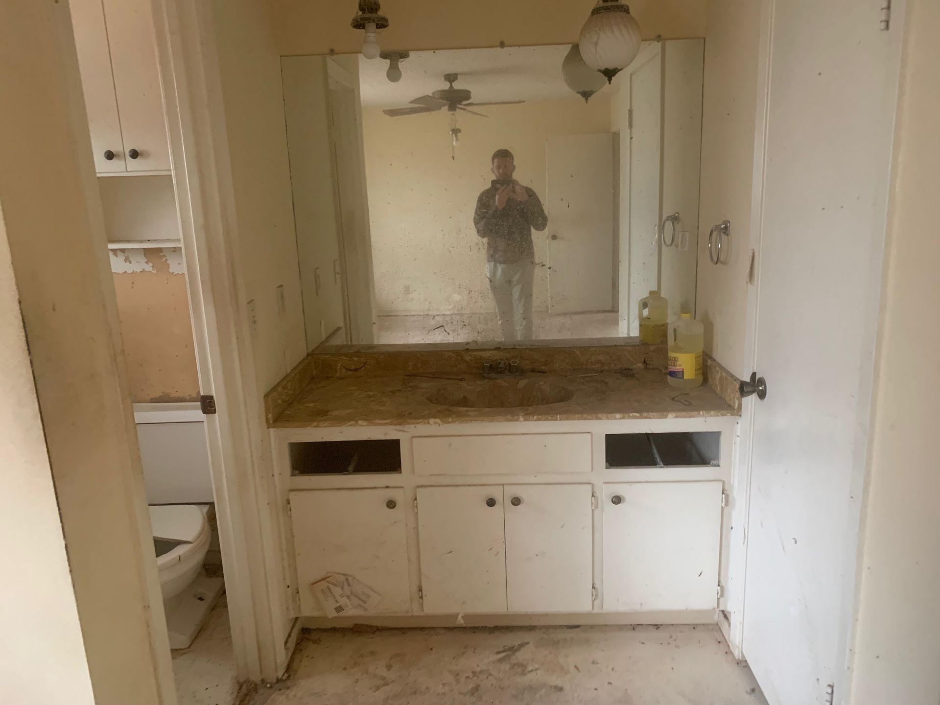 A bathroom with a sink, toilet, and mirror.