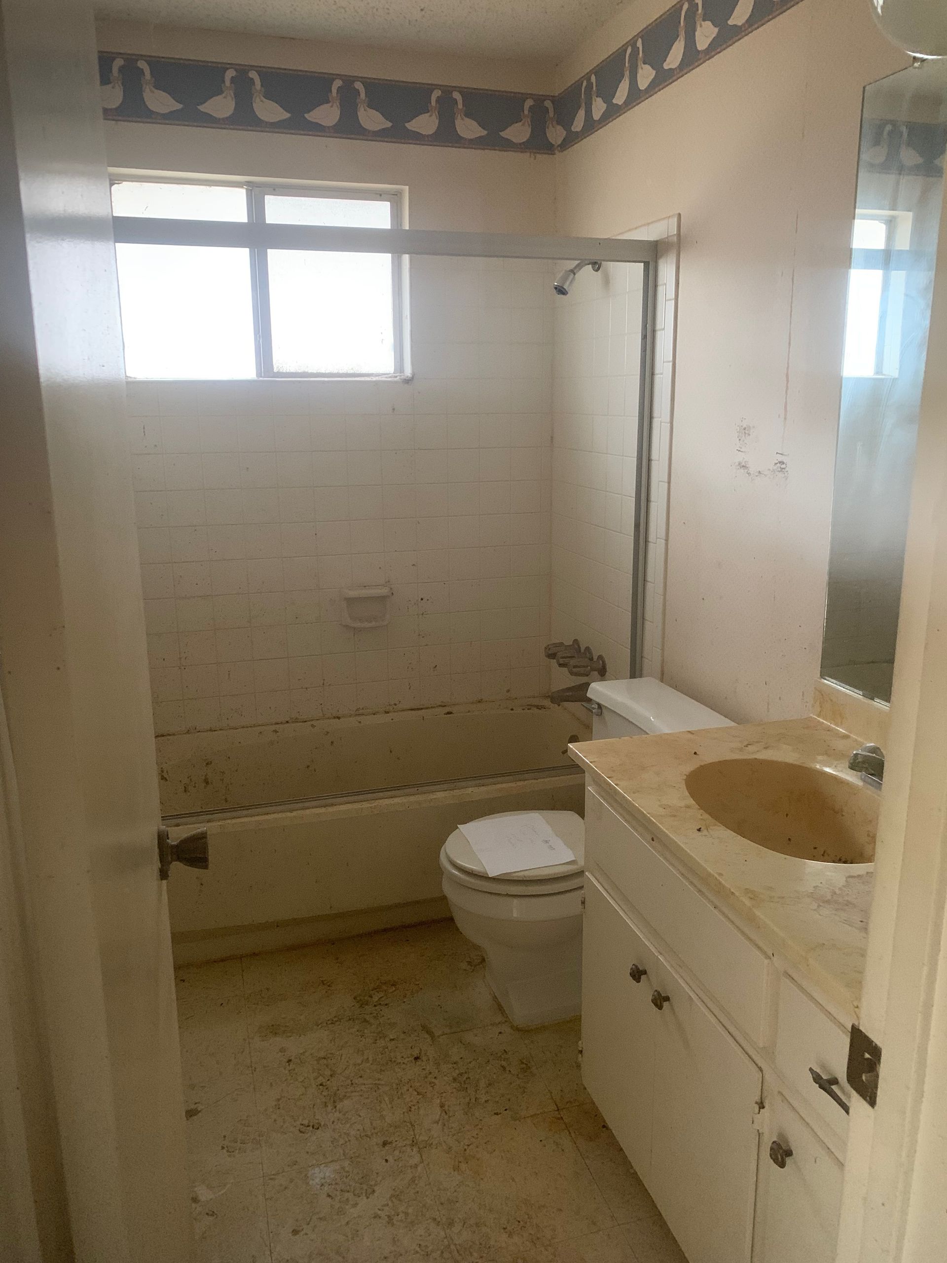 A bathroom with a toilet, sink, and bathtub.