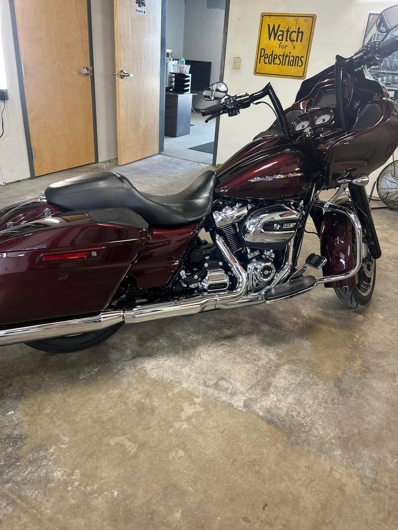 Maroon touring motorcycle parked indoors on a wet concrete floor.