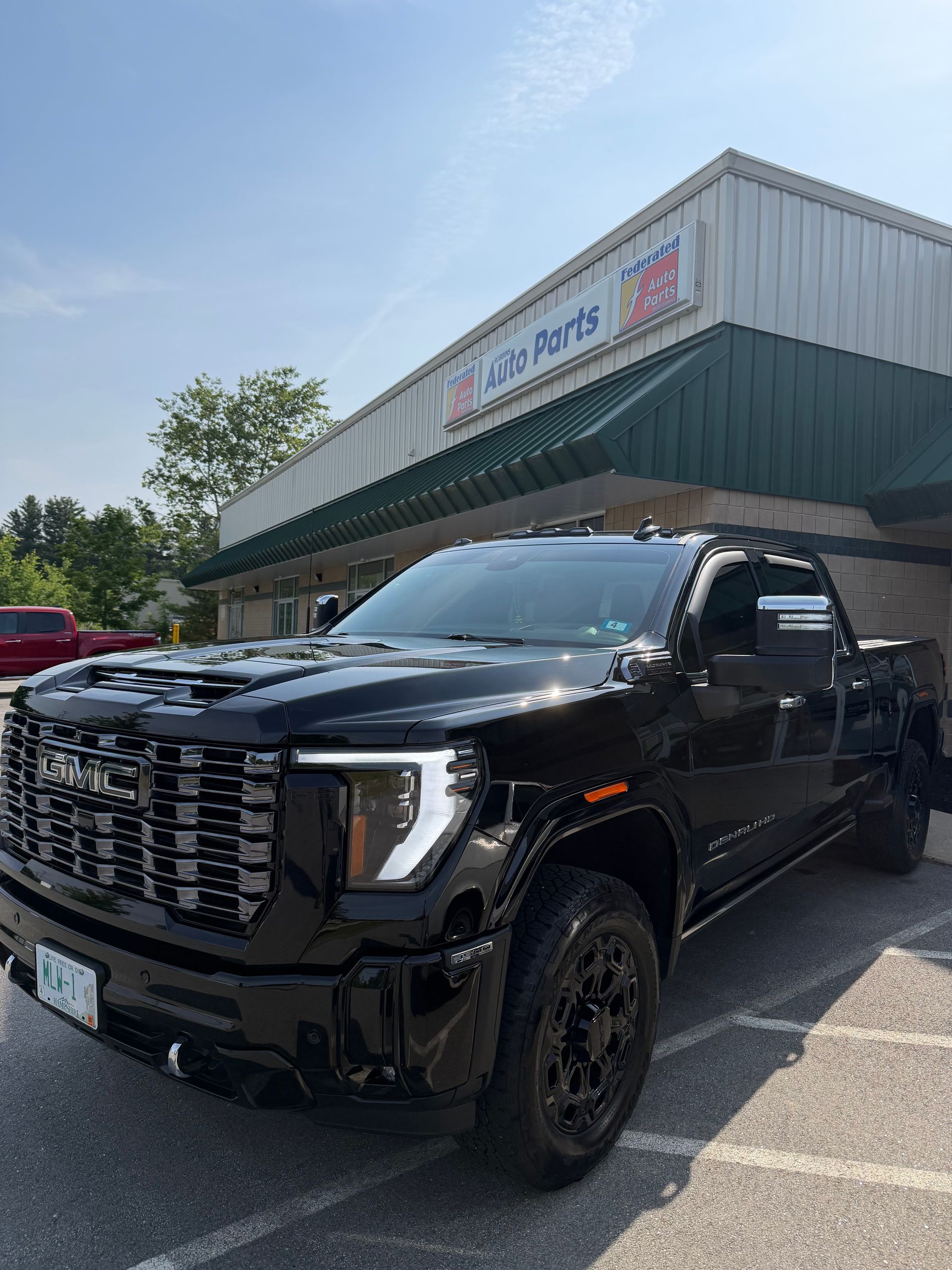 Black pickup truck parked outside a storefront on a sunny day