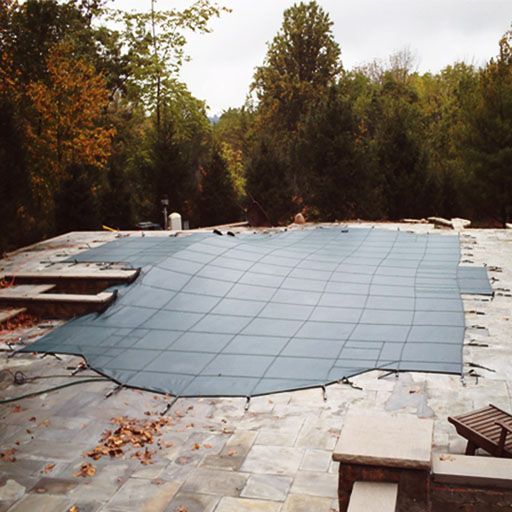A large blue tarp is covering a swimming pool