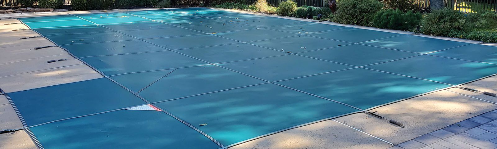 A swimming pool with a blue cover on it.