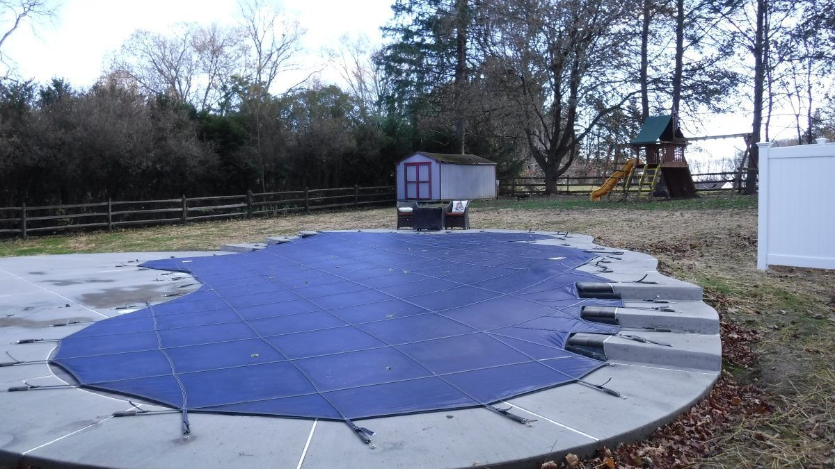 A swimming pool with a blue cover on it