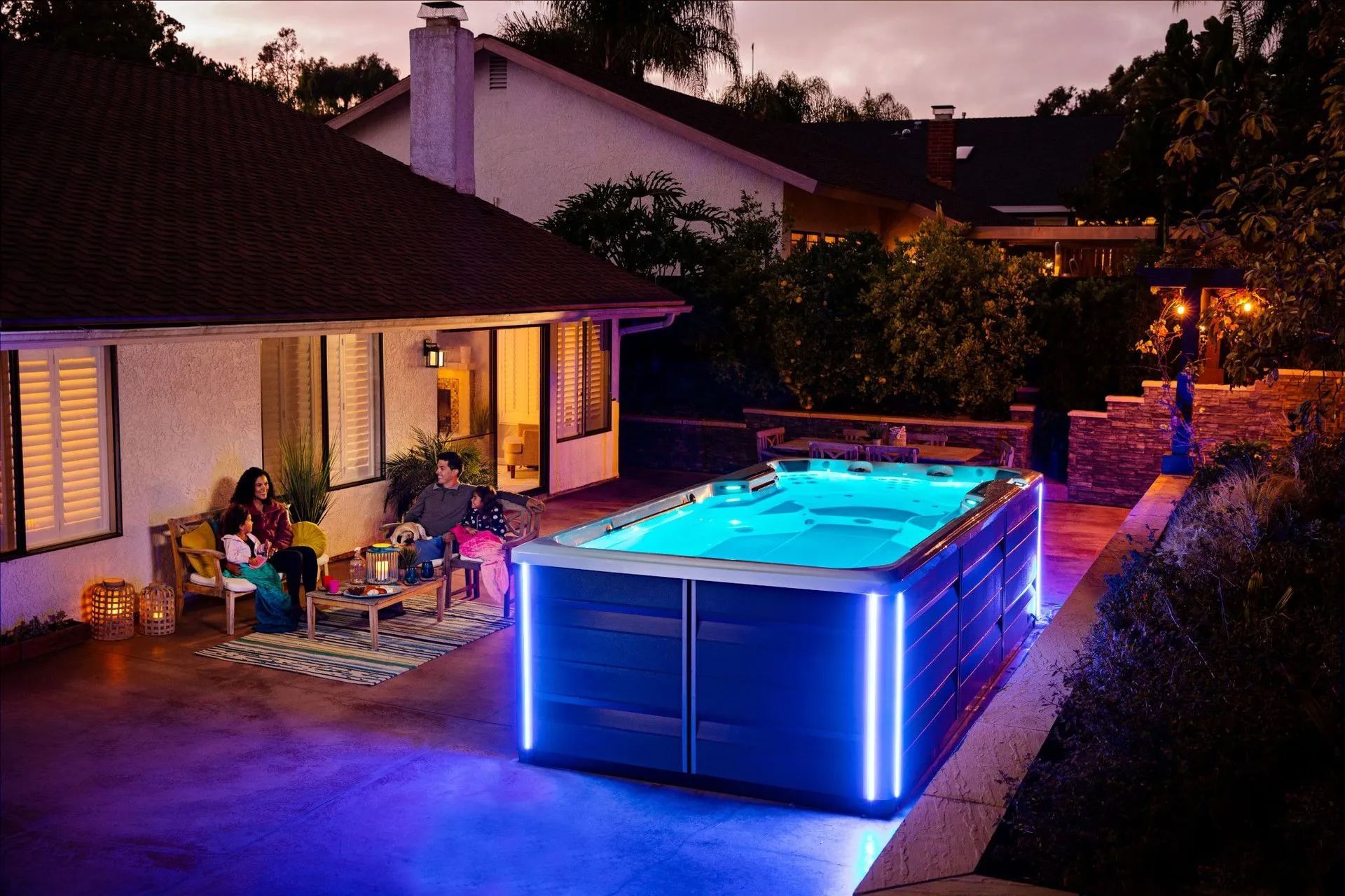 A large swimming pool is in the backyard of a house.