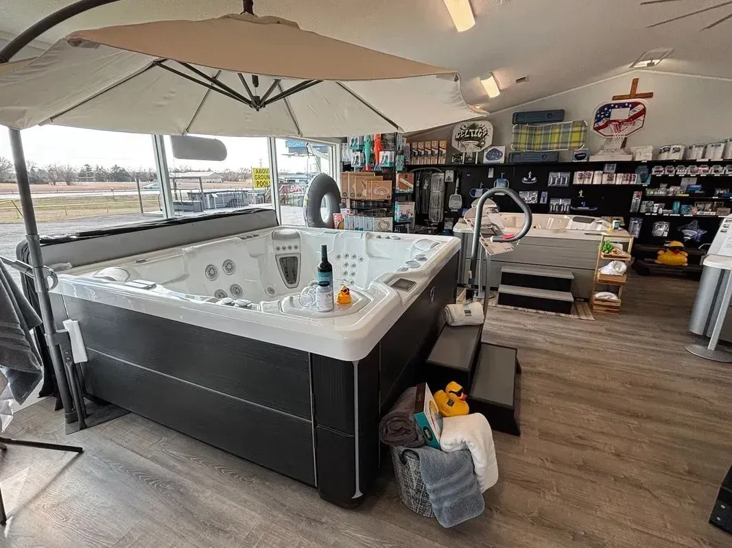 A hot tub is sitting under an umbrella in a store.