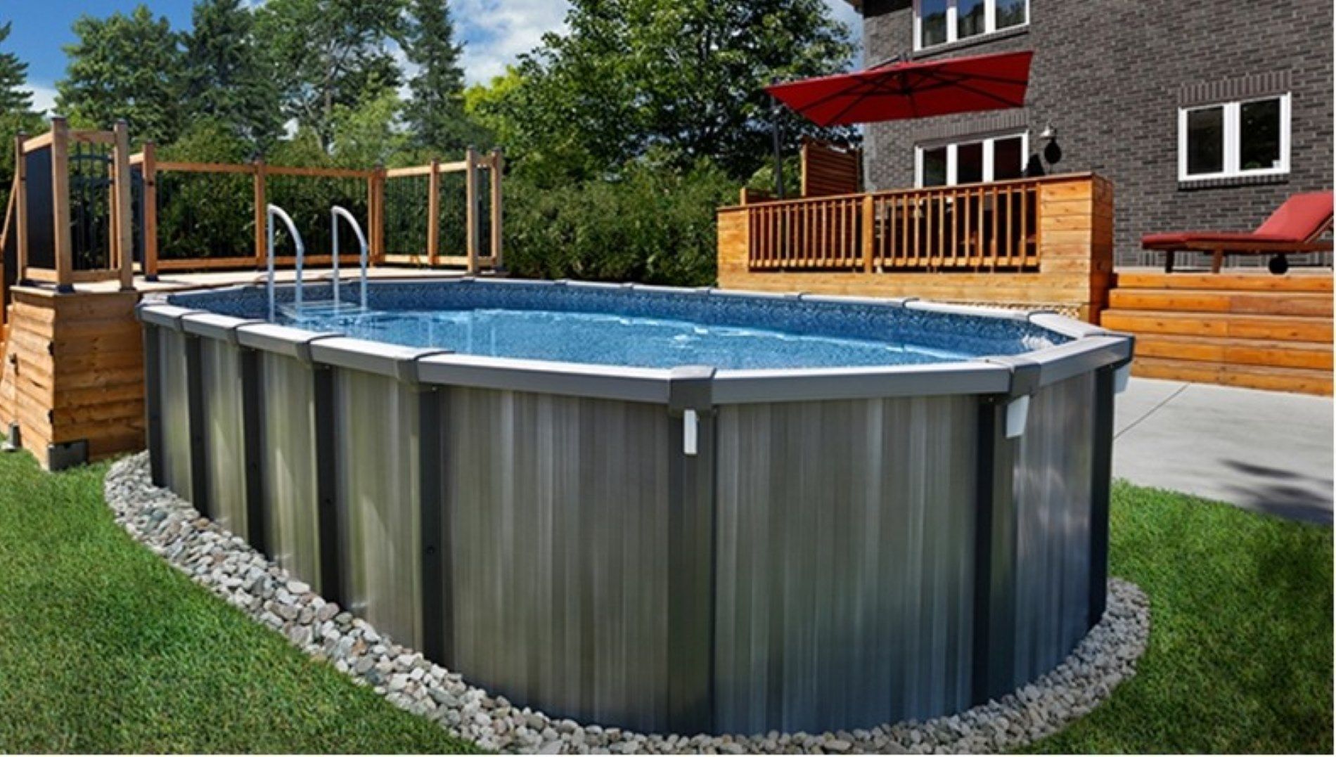 A large swimming pool is sitting in the grass in front of a house.