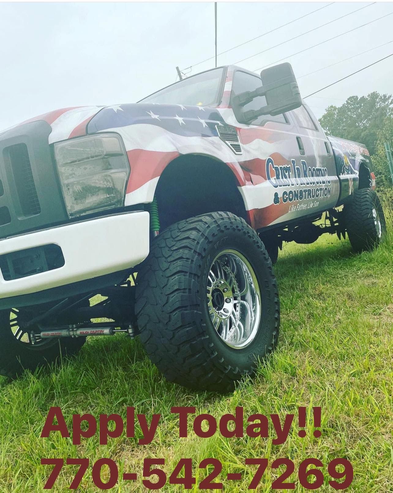 Lifted white truck with patriotic graphics parked on grass; “Apply Today!! 770-542-7269” text below.