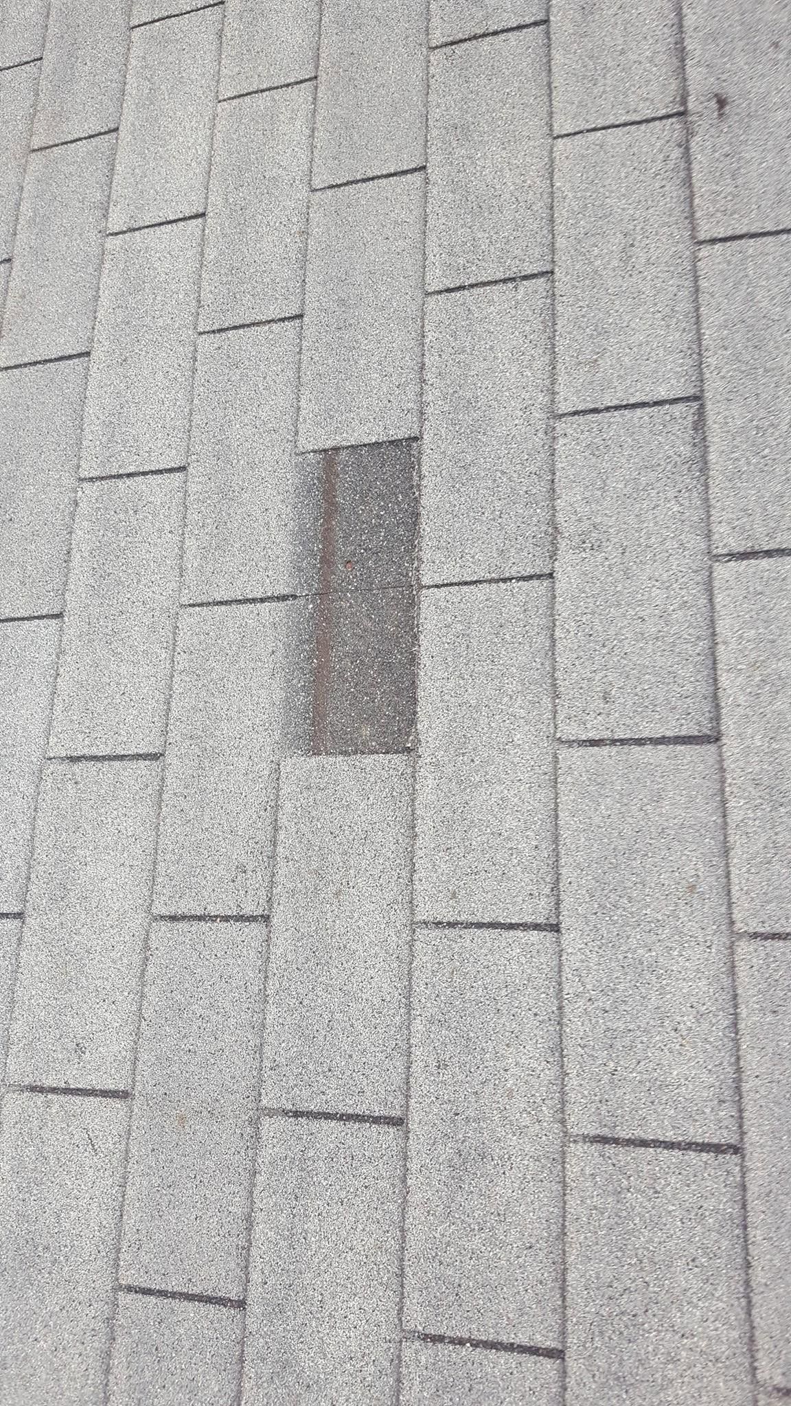 Gray shingled roof with a small dark rectangular patch in the center.