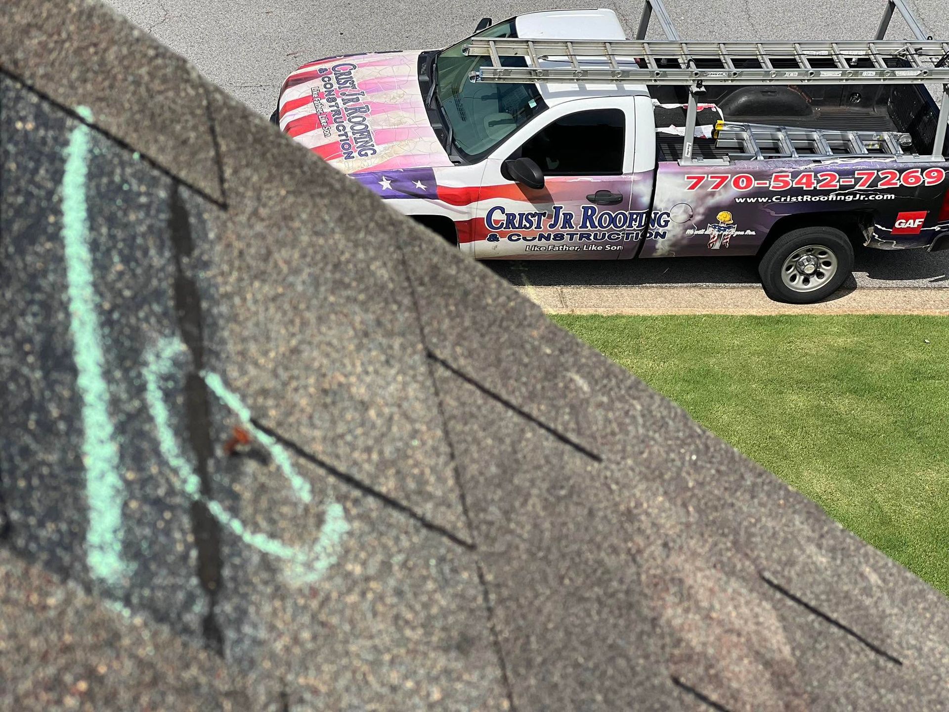 Graffiti on a concrete wall with a truck parked on grass in the background
