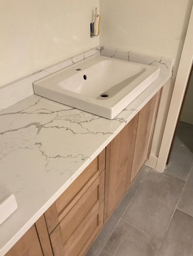 A bathroom counter with a sink and wooden cabinets