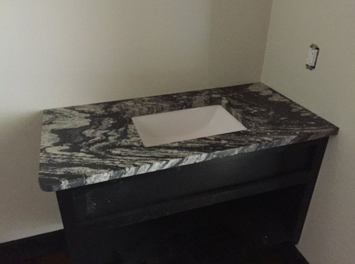 A bathroom sink with a marble counter top