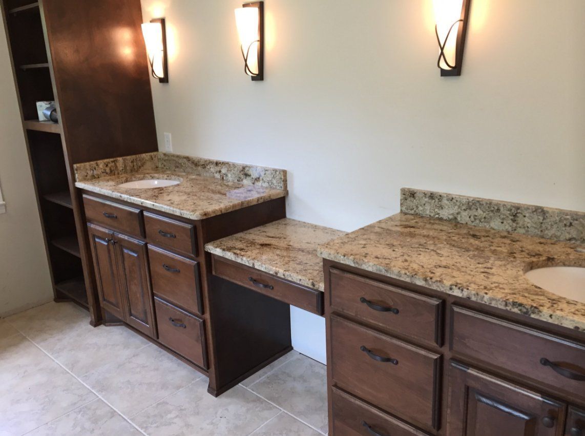 A bathroom with two sinks and granite counter tops