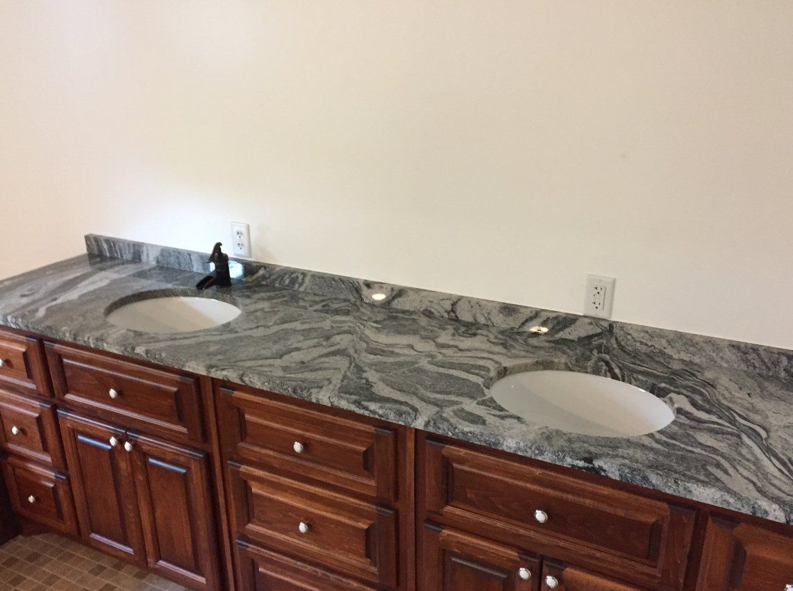 A bathroom with two sinks and wooden cabinets.
