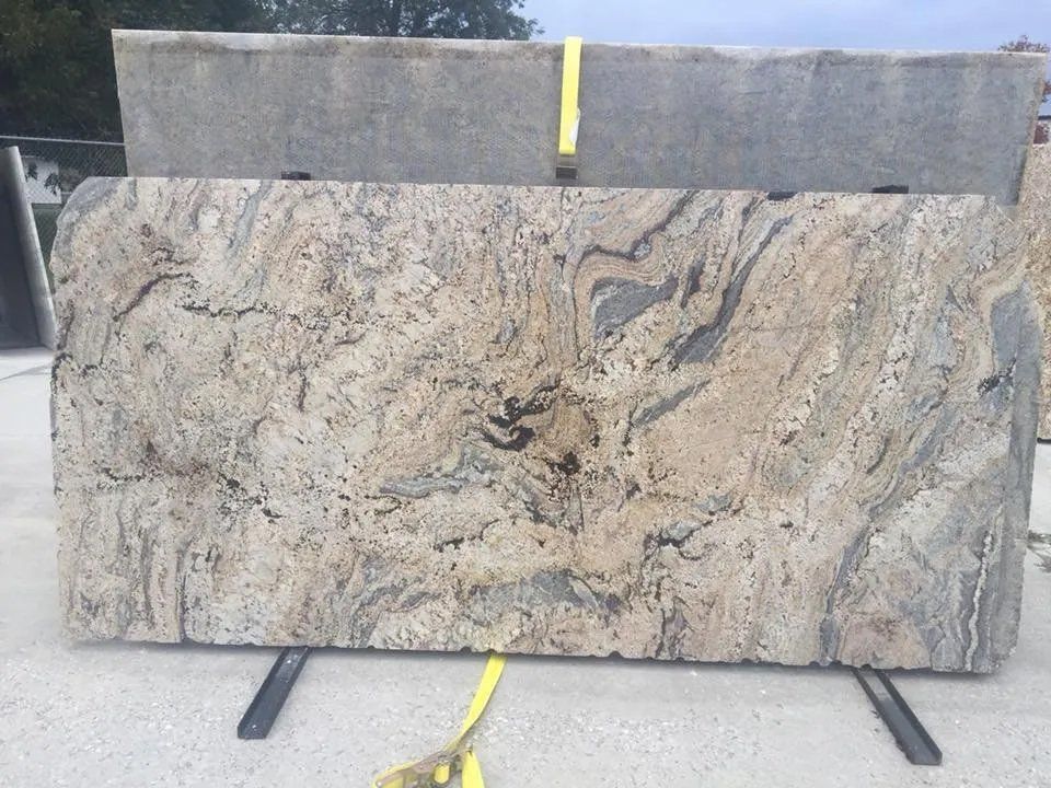 A large slab of granite is tied with a yellow strap