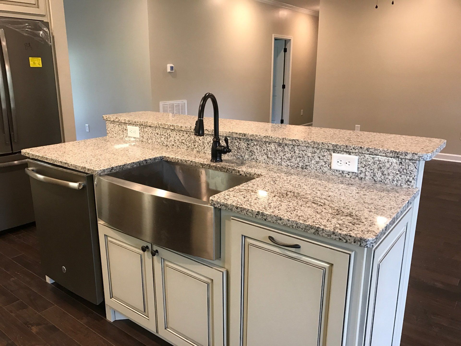 A kitchen with a stainless steel sink and granite counter tops