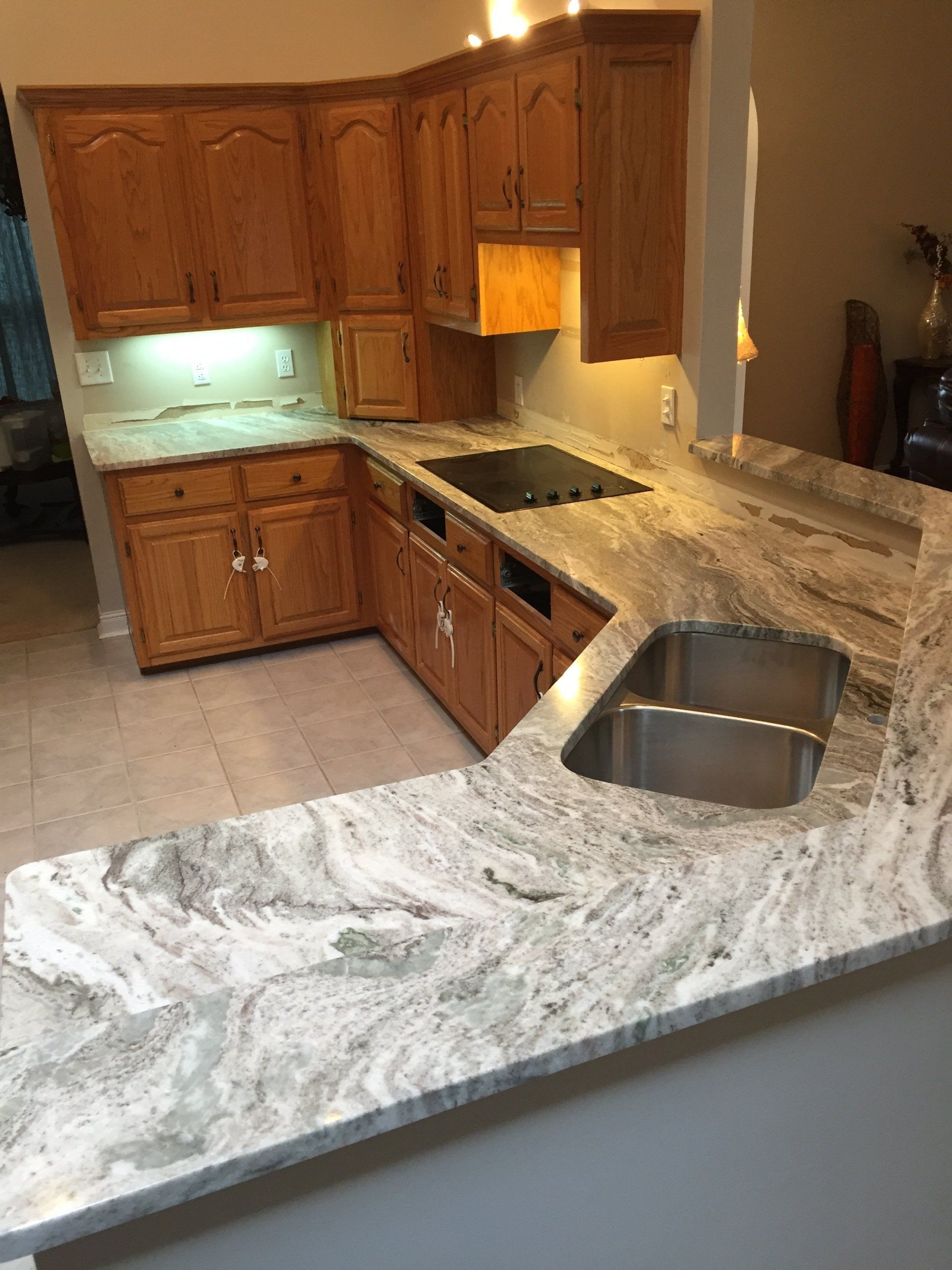 A kitchen with granite counter tops and wooden cabinets