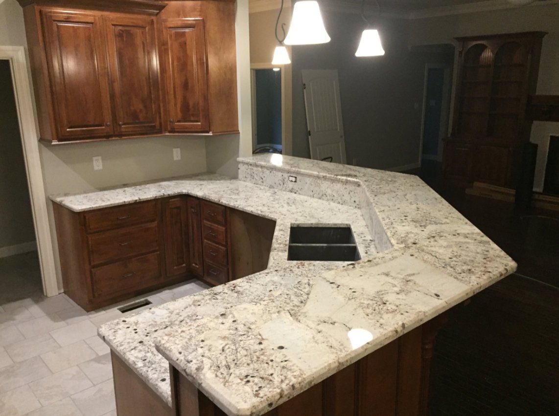 A kitchen with granite counter tops and wooden cabinets.