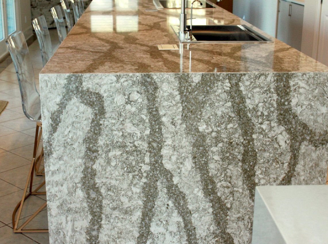 A kitchen with a large granite counter top and a sink.