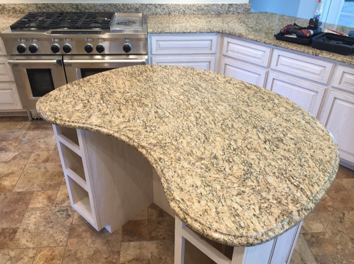 A kitchen with a large granite counter top and a stove.