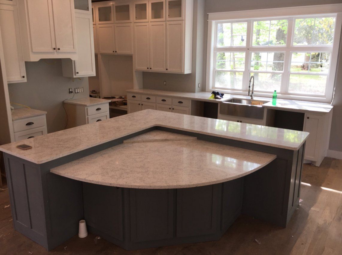 A kitchen with a large island and a sink.