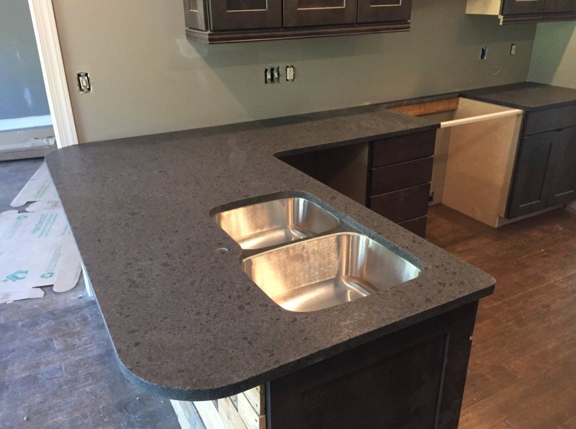 A kitchen with two sinks and a granite counter top.