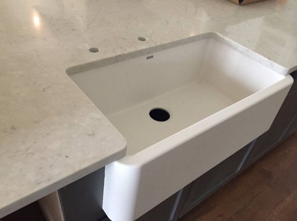 A white kitchen sink with a hole in the middle of it