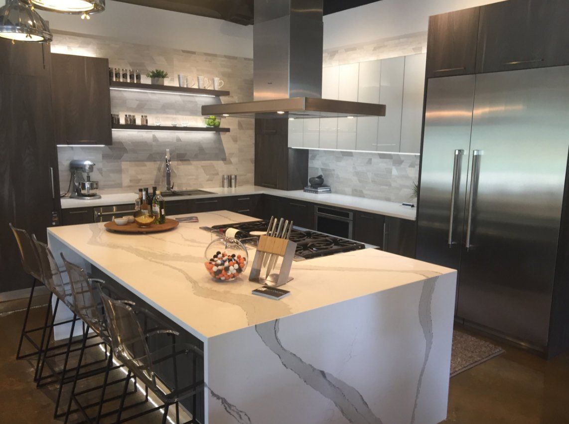 A kitchen with a large island and stainless steel appliances.