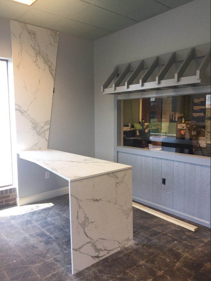 A room with a long white table and a window.