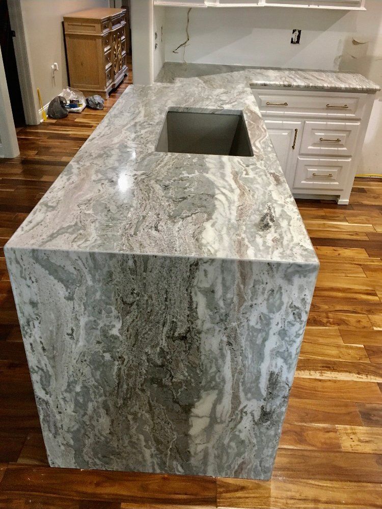 A kitchen with a large granite counter top and a sink.