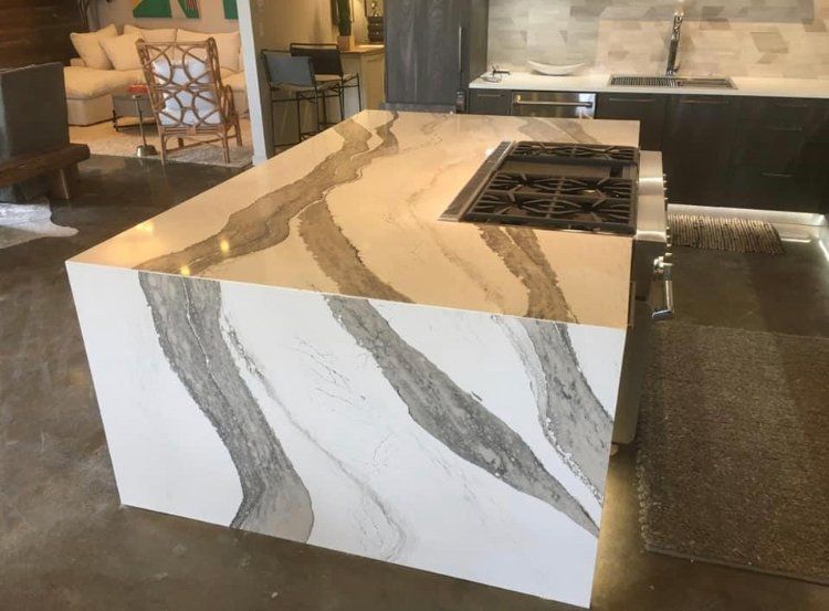 A kitchen with a large island and a stove top oven