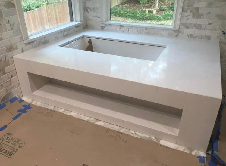 A bathtub is being built in a bathroom next to a window.