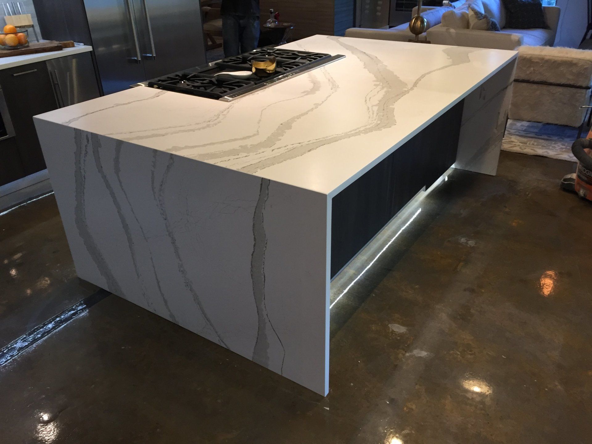 A large white counter top in a kitchen with a stove top oven.