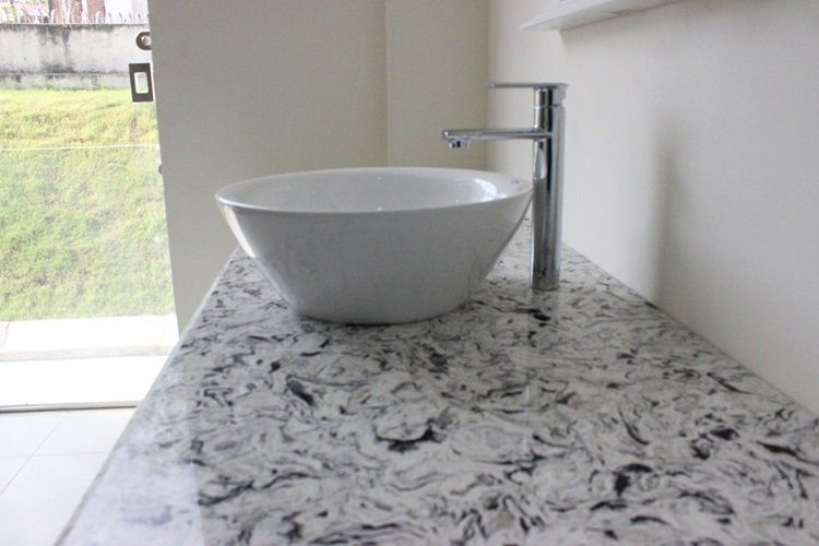 A bathroom sink is sitting on top of a granite counter top.